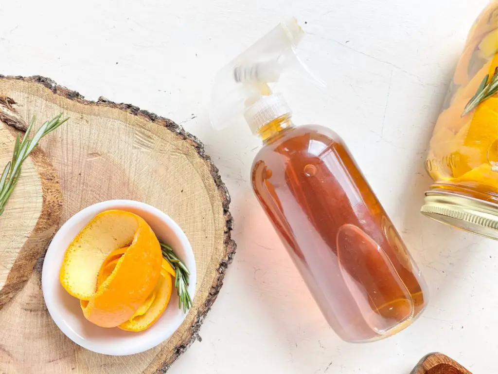 orange peels and vinegar cleaner strained into glass spray jar 